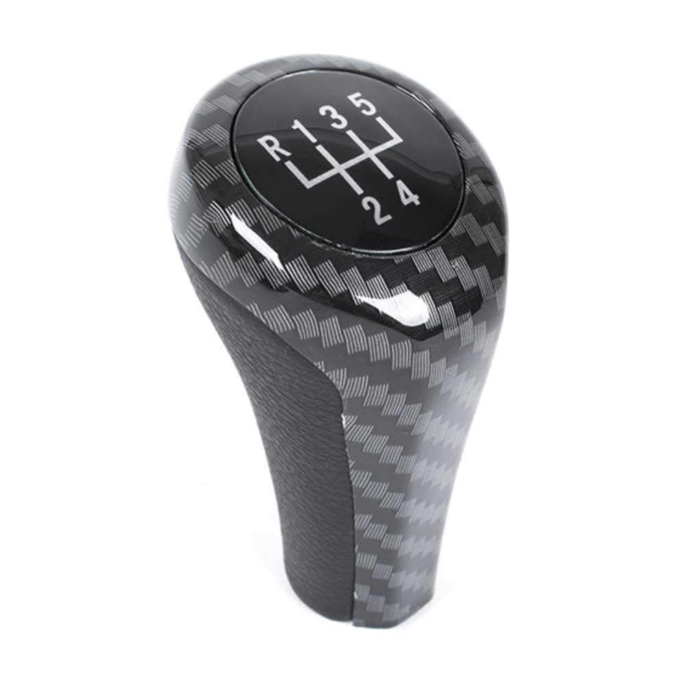 Fekete és carbon színű, 5 sebességes BMW váltógomb. Üveg számlappal.